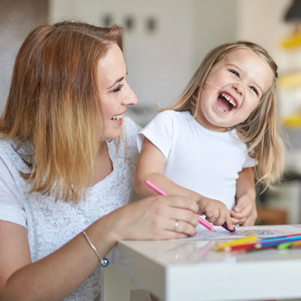 Eine Mutter und ihre kleine Tochter zeichnen glücklich und spielfreudig zusammen