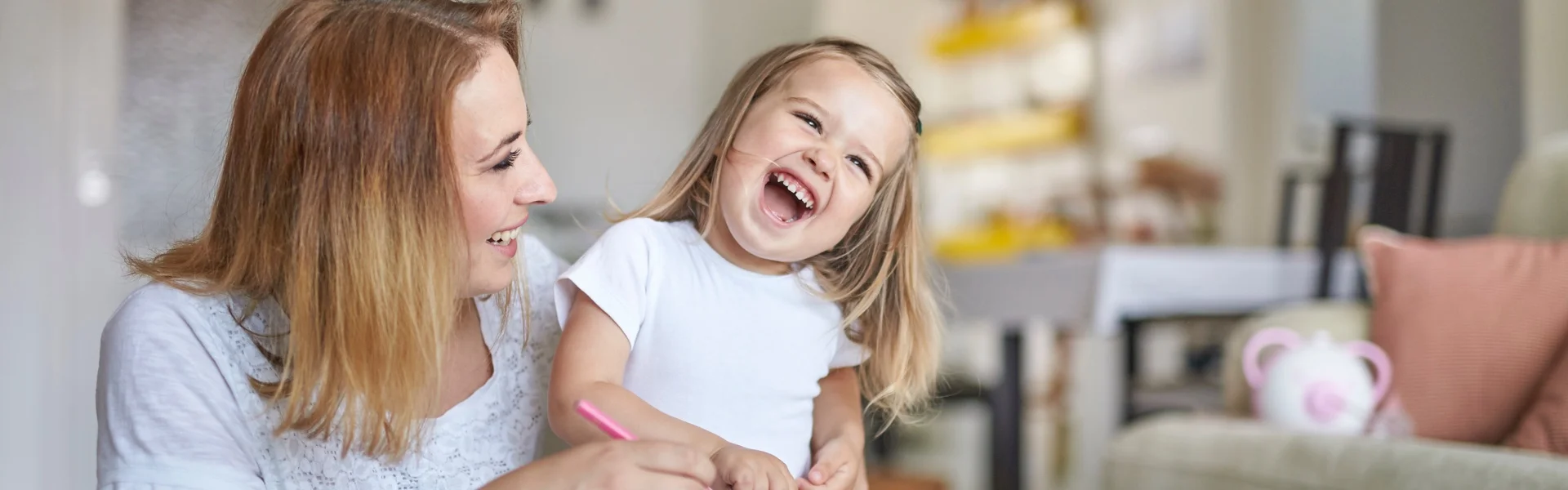 Eine Mutter und ihre kleine Tochter zeichnen glücklich und spielfreudig zusammen