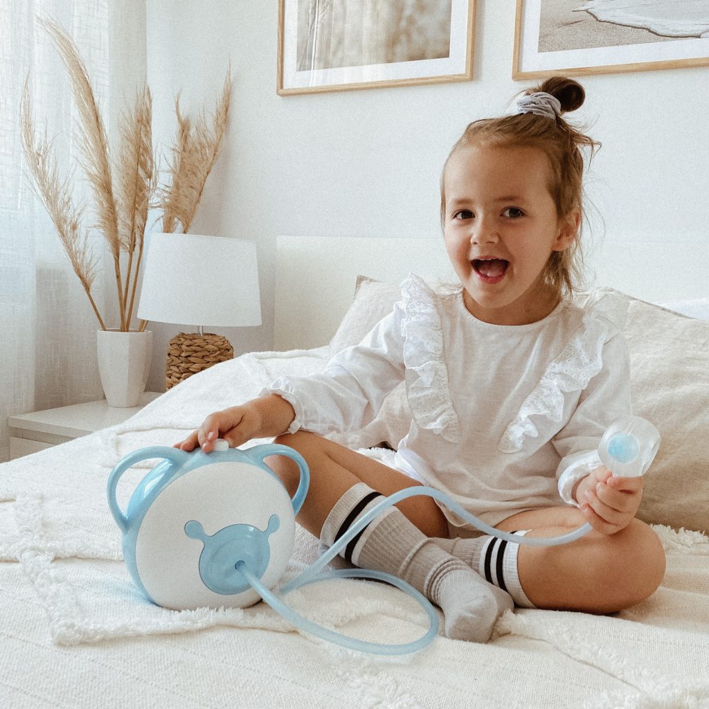 Ein schickes kleines Mädchen mit dem Nosiboo Pro elektrischen Baby Nasensauger