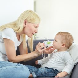 Eine Frau putzt ihrem Sohn die verstopfte Nase mit Hilfe des Nosiboo Eco Baby Mundnasensaugers