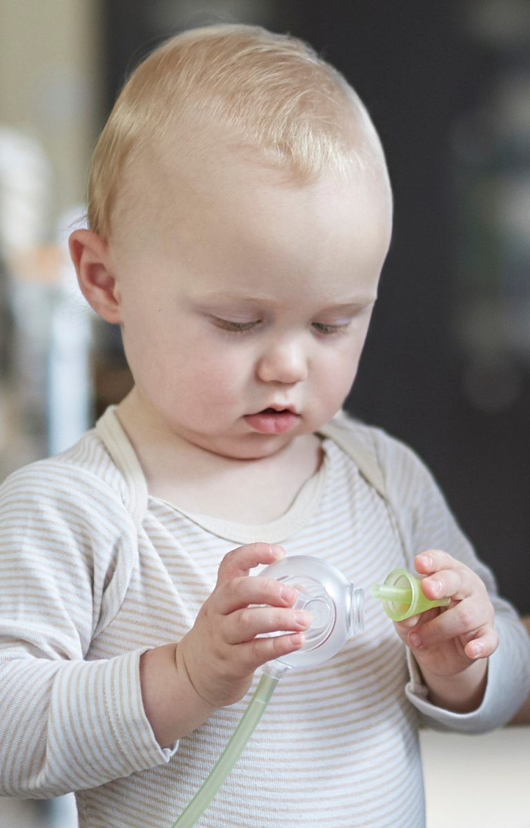 Ein kleiner Junge mit dem elektrischen Baby Nasensauger Nosiboo Pro